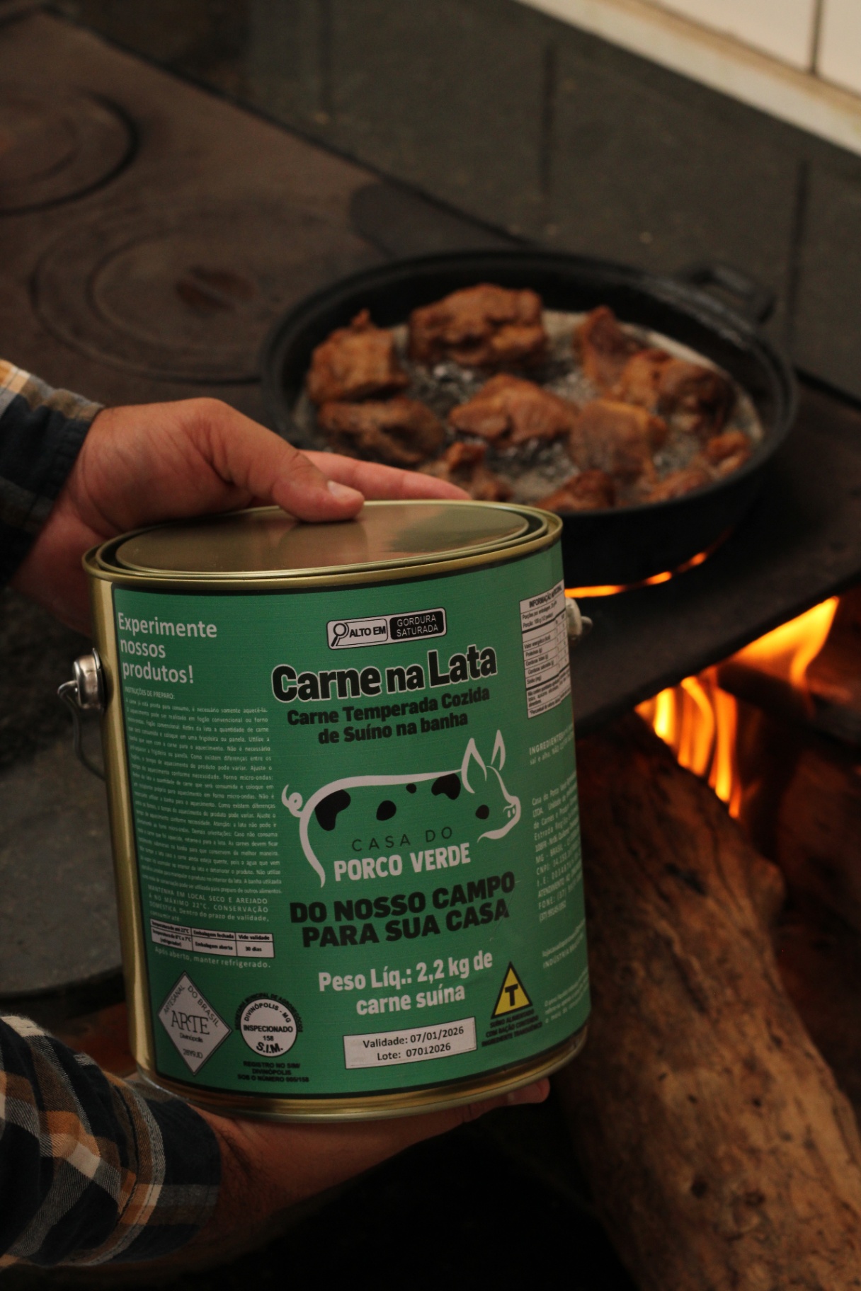 Lata de Carne na Lata Casa do Porco Verde ao lado do fogão a lenha com a carne dourando na panela